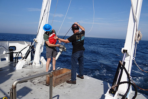 Chief Scientist, Matthew Hommeyer (left), and FIO Science Technician, Andrew Warren, prepare to deploy the underway sound velocity profiler (underway SVP) towfish aboard the R/V W.T. Hogarth in February 2021. 