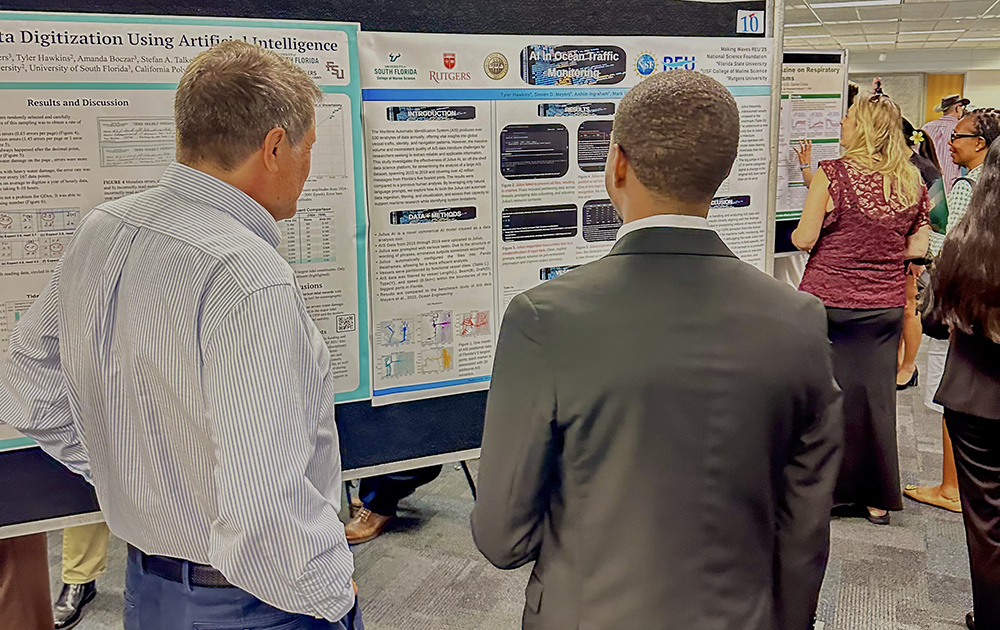 REU scholar Tyler Hawkins discussing his summer research on artificial intelligence in ocean traffic monitoring with David Naar, associate dean of the USF College of Marine Science and professor of geological oceanography. Photo Credit: Jess Van Vaerenbergh