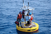 Robert Weisberg (right), USF Distinguished University Professor, stands on a buoy with Jay Law (left), research scientist in the Ocean Circulation Lab at the USF College of Marine Science.