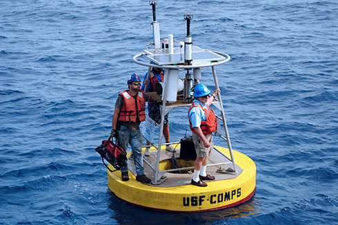 Robert Weisberg (right), USF Distinguished University Professor, stands on a buoy with Jay Law (left), research scientist in the Ocean Circulation Lab