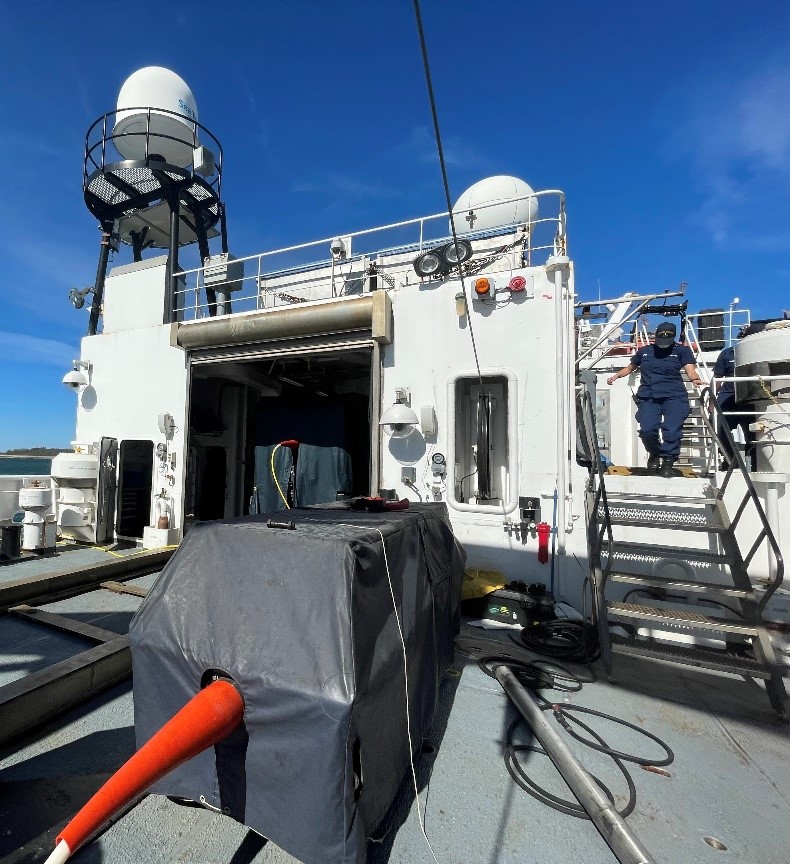 ROV's Deep Discoverer (back, in ROV bay) and its companion, Seirios (front), on the back deck of the Okeanos Explorer. The dual-system configuration provides perspectives from both the main ROV Deep Discoverer as well as a bird’s eye view of it from above it where Seirios hovers.