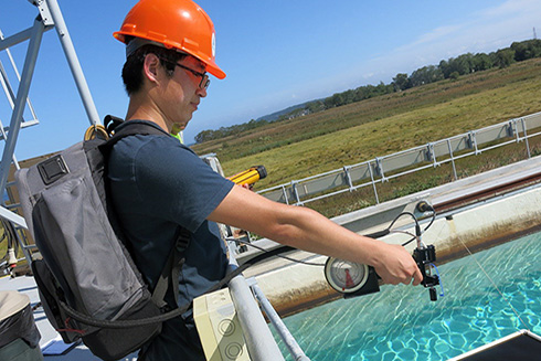 Shaojie Sun measured spectral reflectance in an oil tank experiment at the Ohmsett facility in New Jersey. Photo Credit: Ohmsett Facility