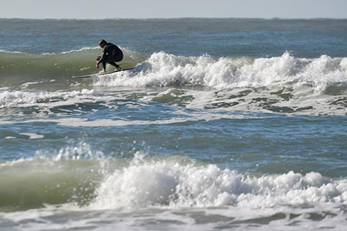A surfer on Siesta Beach takes advantage of swells created by a storm front that brought windy weather over the weekend. Morning temperatures dipped into the low 40s across the area. Photo Credit: Herald-Tribune staff photo / Mike Lang