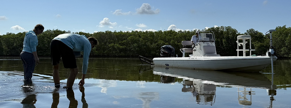 Layne Leggett and AJ Gross gather oyster samples, as Captain Rob Gorta looks on.