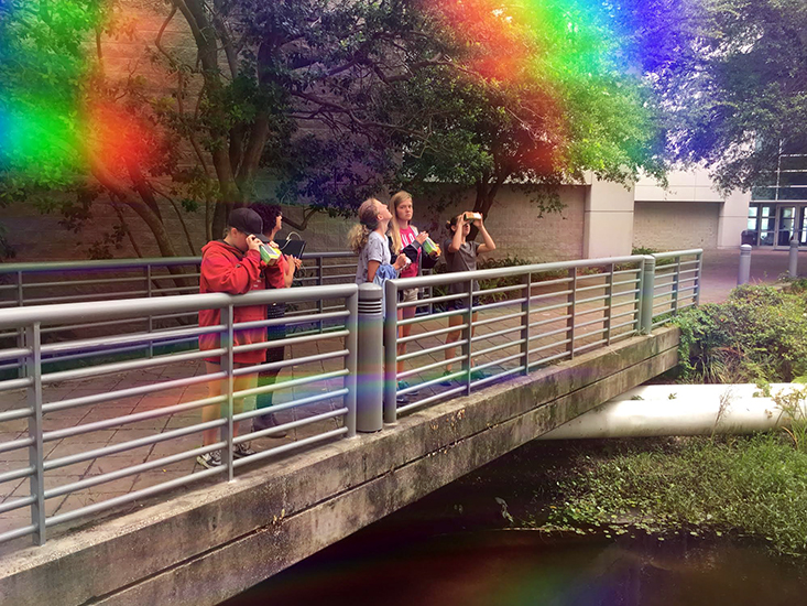 The rainbow “filter” for the photo was made using the eye piece of the spectroscope the girls made during the lab.
