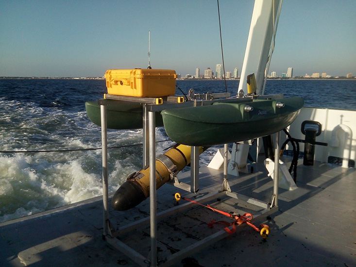 An autonomous underwater glider rests securely in its echosounder calibration float aboard the deck of the R/V Hogarth.
