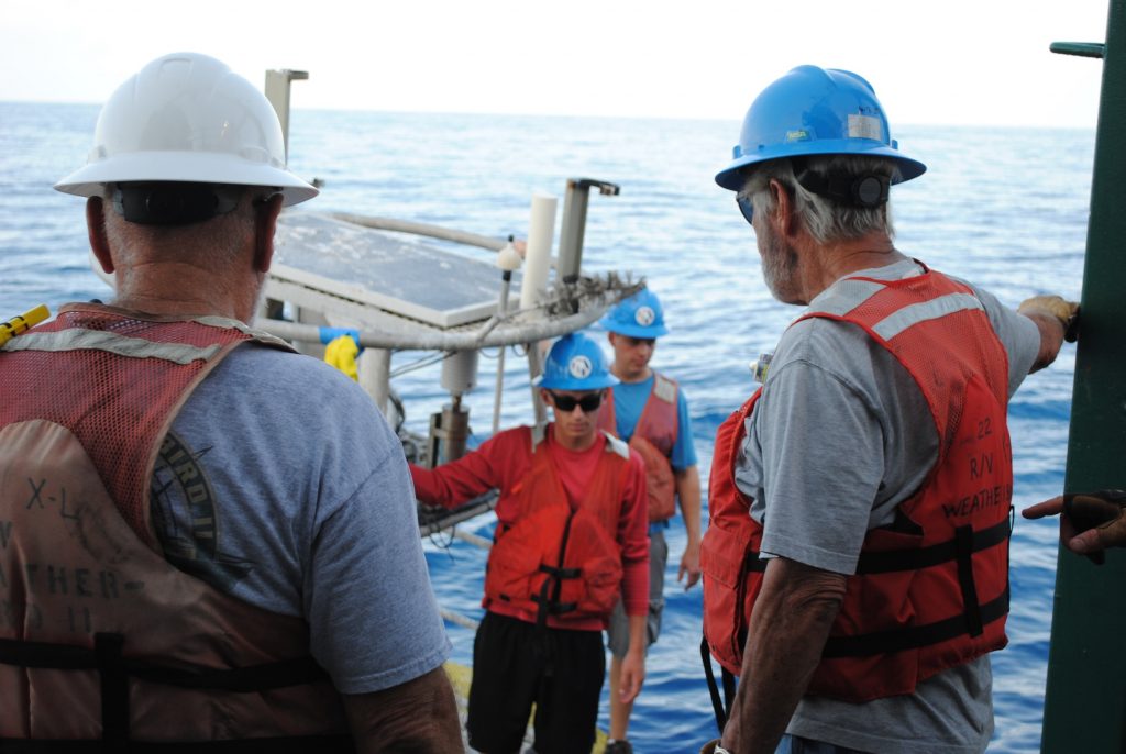 William Ely (buoy, foreground) and Talon Bullard (buoy, background) prepare to reboard the Weatherbird II after a trip on a newly deployed buoy.