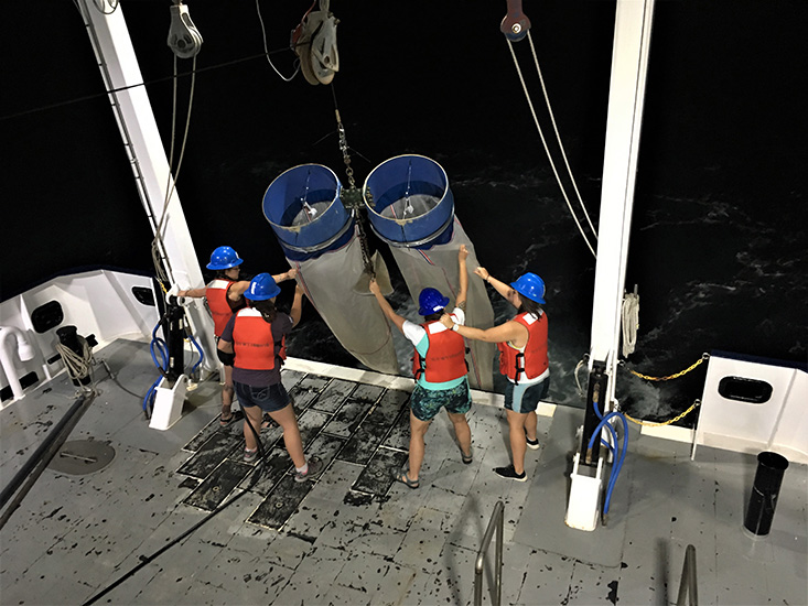 Working the overnight shift, Grace Koziol, Brianna Michaud, Nicole Seiden, and Abby Blackburn (left to right) control the Bongo nets as they’re hoisted aboard the R/V Hogarth. 