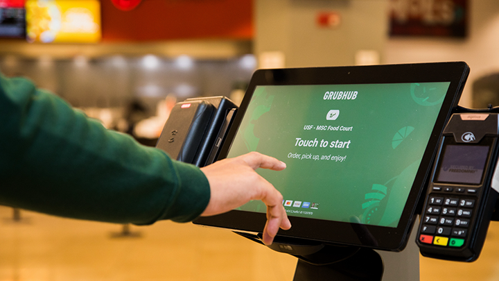 Person tapping a screen to online order through GrubHub