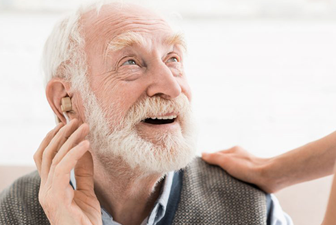 Older man wears a hearing aid
