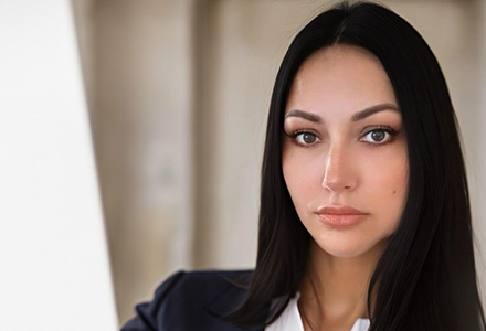 Kristen Bubis, with long, dark hair, a dark suit jacket and white shirt