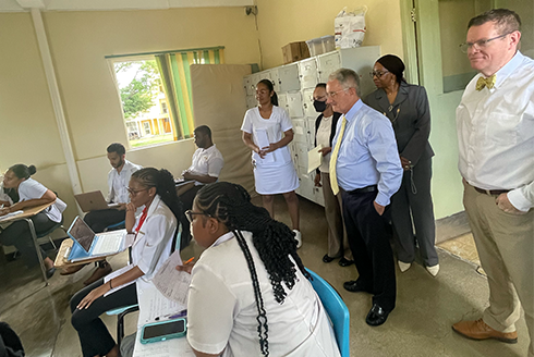 Group of nurses in Jamaica sit at desks joined by leaders from USF Health