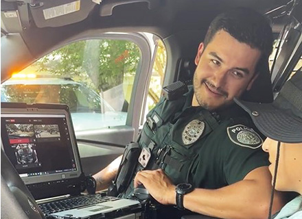 a campus policeman shows a camper the inside of his cruiser
