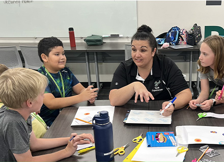 a teacher speaks to a group of campers