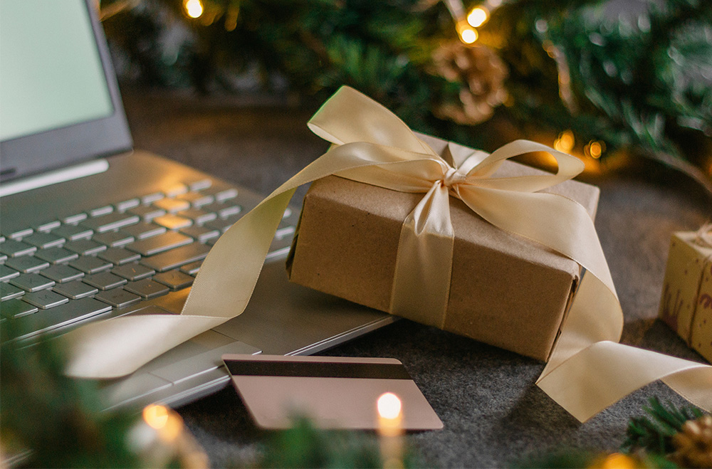 Small gift, credit card and computer with holiday decor