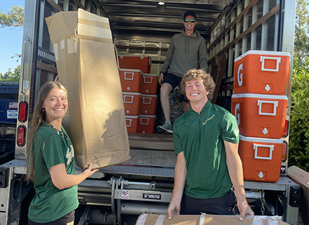 lauren unloads a truck with two other students
