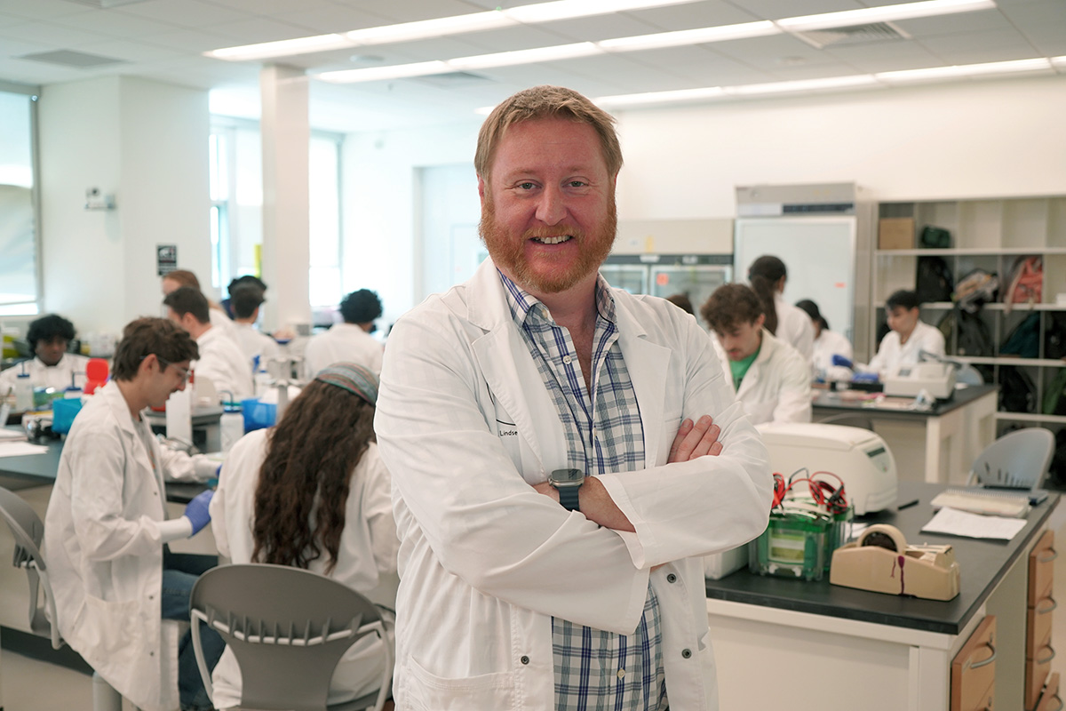 Shaw standing with his students in the lab in the background