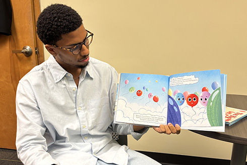 Jayden Haggler holds a book he authored