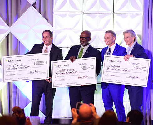 Mayors of Clearwater, St. Petersburg and Tampa pose with giant checks and Arnie Bellini