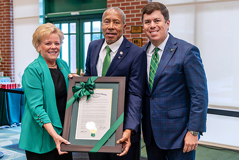 President Rhea Law, Darryl Rouson and Mike Griffin hold up a plaque at the BOT meeting