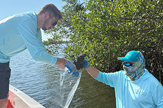 Two marine scientists on the water