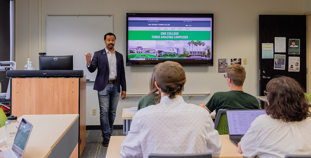USF faculty member speaks at the front of a classroom