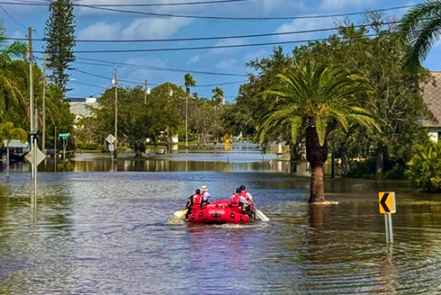 Group of people on boat in a flooded road