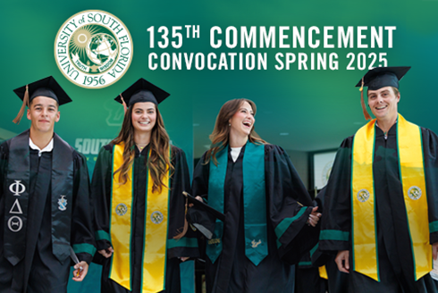 Four USF students in regalia stand with the words