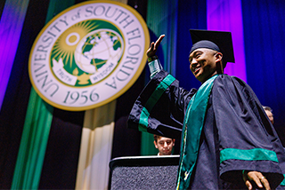 Student walks across stage at commencement