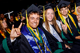students sit giving the go bulls hand signal