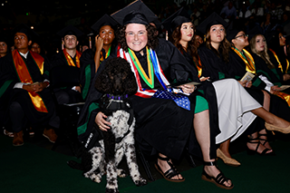 student with dog at USF commencement