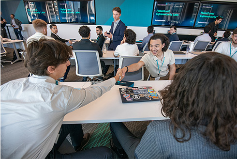 Student interns shake hands at Reliaquest