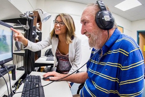 Older man wearing headphones in a science lab