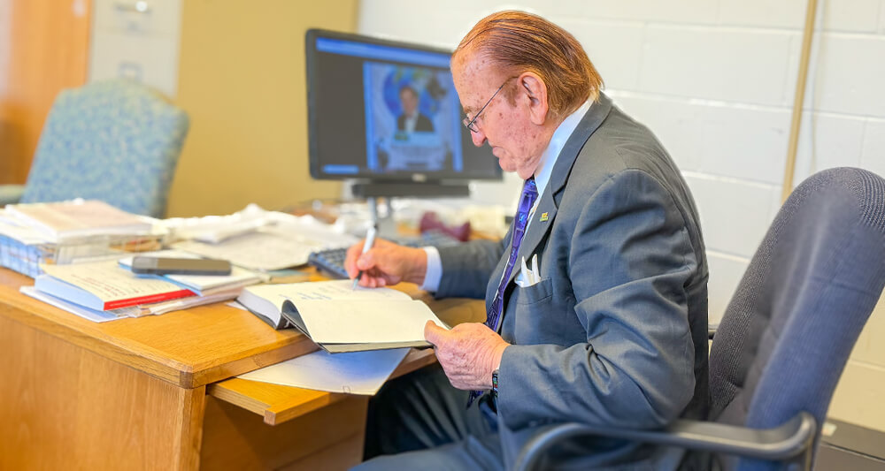 Chris P. Tsokos sits at his desk preparing for a weekly meeting
