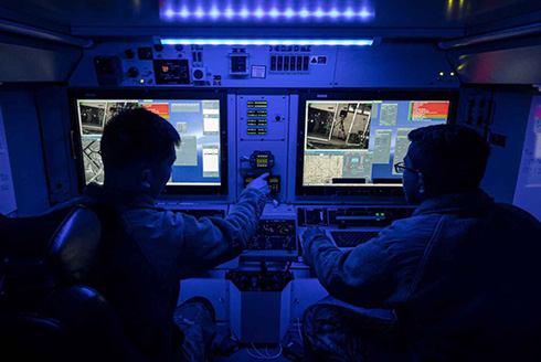 Two men sit at simulation monitors