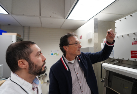 Researchers examine a vial filled with a newly created crystal material