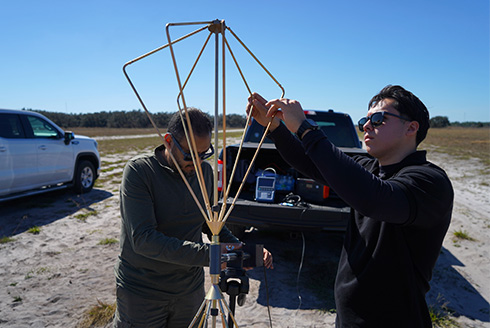USF student and IAE engineer work on Army device