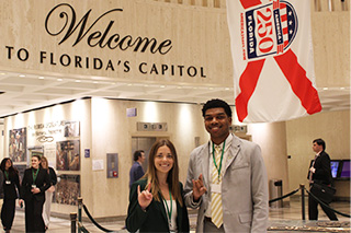Two students give Go Bulls hand signal