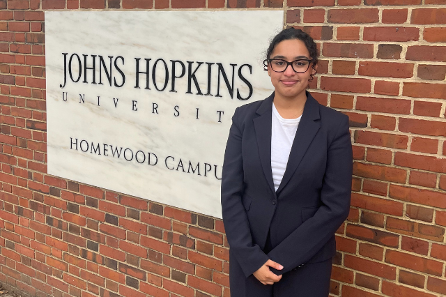 Avani standing at entrance to Johns Hopkins