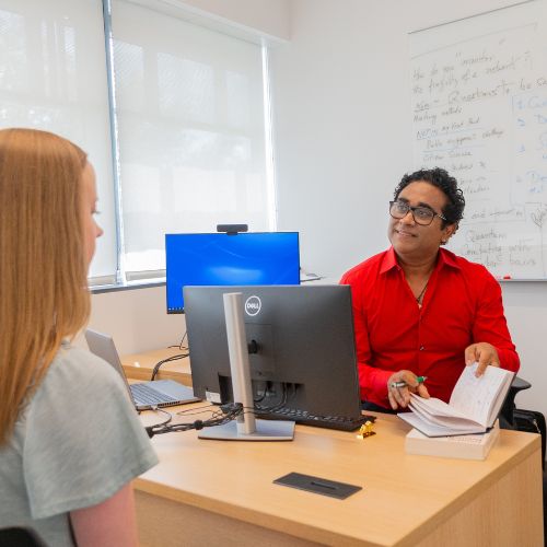 Dr. Basu in an appointment with his student in his office.