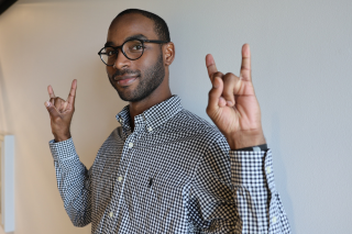 Derrick Dawson holding up both hands with "go bulls" sign