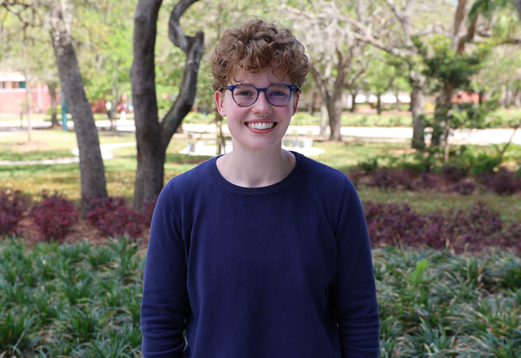 Gray Zeisse headshot outside in front of trees