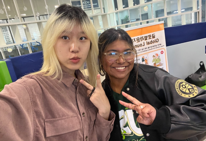 Madiha (right) poses with her Korean pen pal (left) holding up peace signs