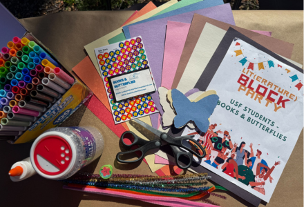 Pile of craft supplies and sign for literature block party