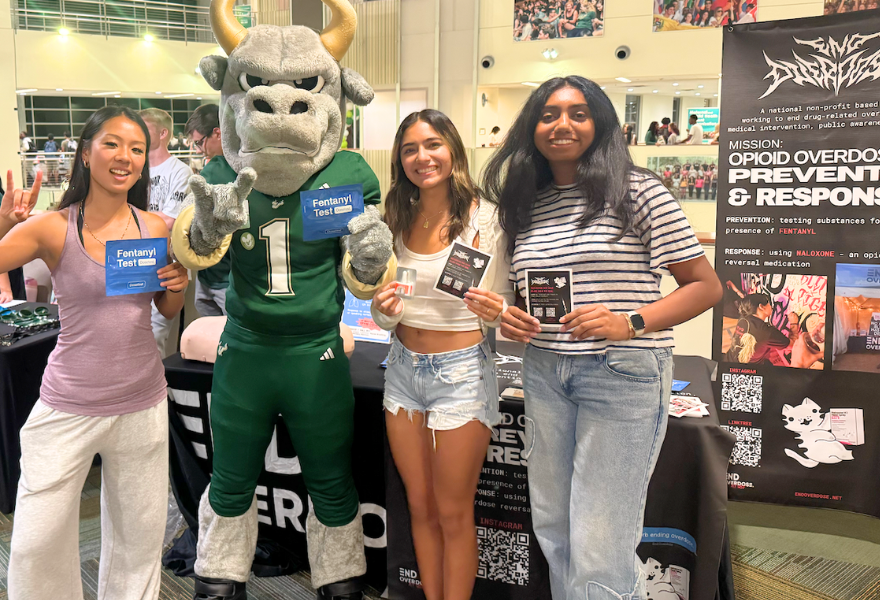 Joy Yang, Carol Agaiby, and Niveditha Chandrkanth distribute tabling materials for End Overdose in USF's Marshall Student Center.