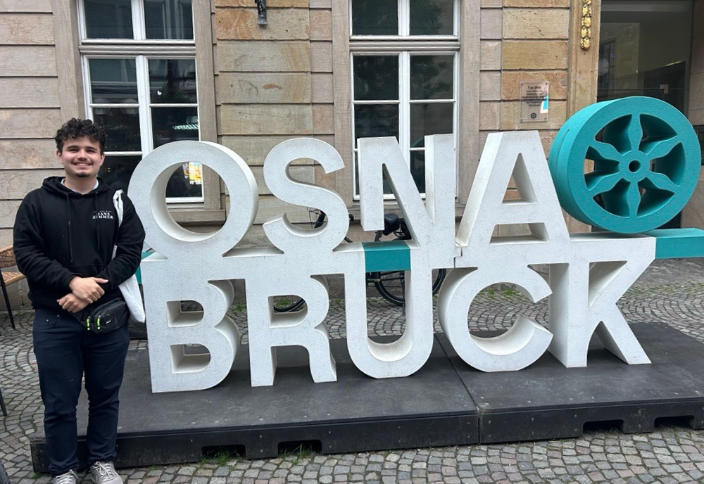 Santi Ramirez Betancur standing in front of Osnabruck sign
