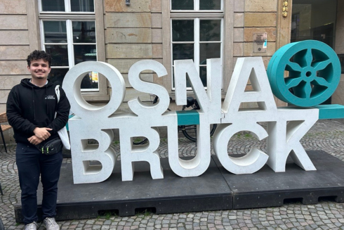 Santi Ramirez Betancur standing in front of Osnabruck sign
