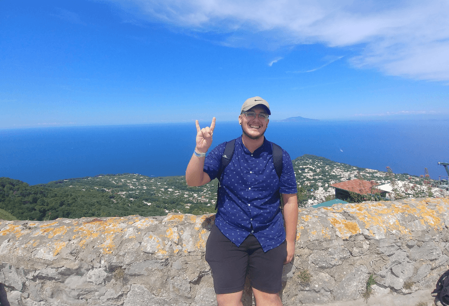 Student posing by a cliff in Italy