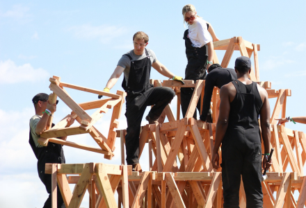 Kobe building a large wood structure with other students