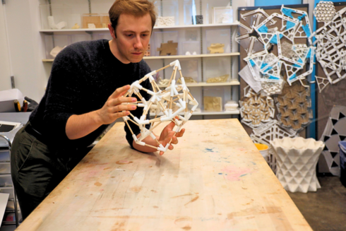 Kobe leaning over a table looking at a model habitat structure